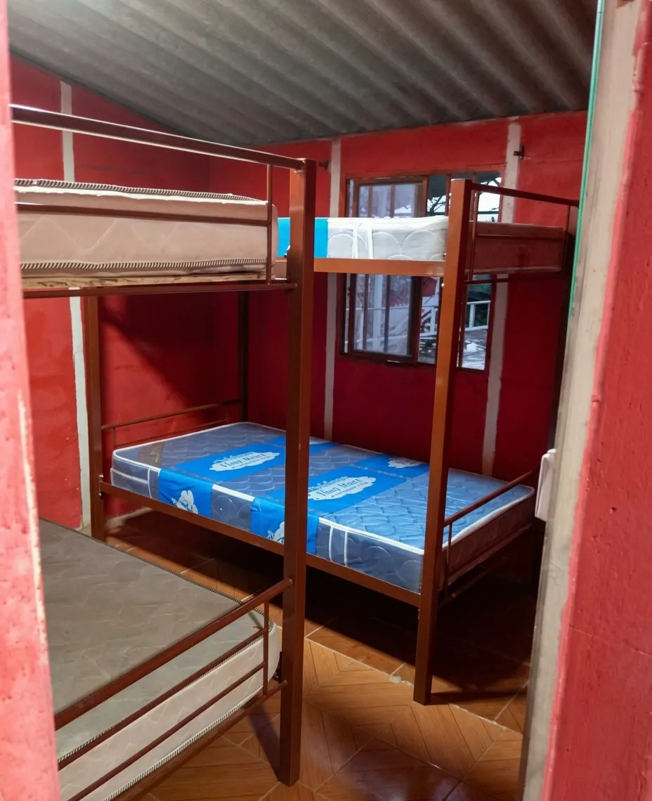 Habitación de Casa 2 con camarotes de estructura metálica y paredes rojas
