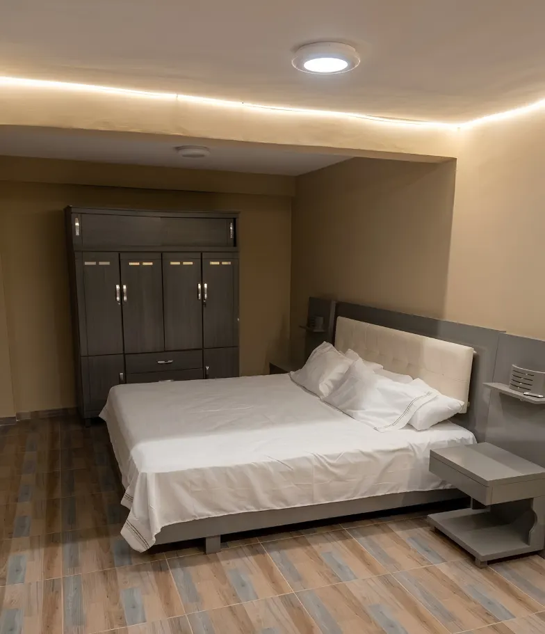 Habitación con cama doble, armario amplio y luz cálida indirecta